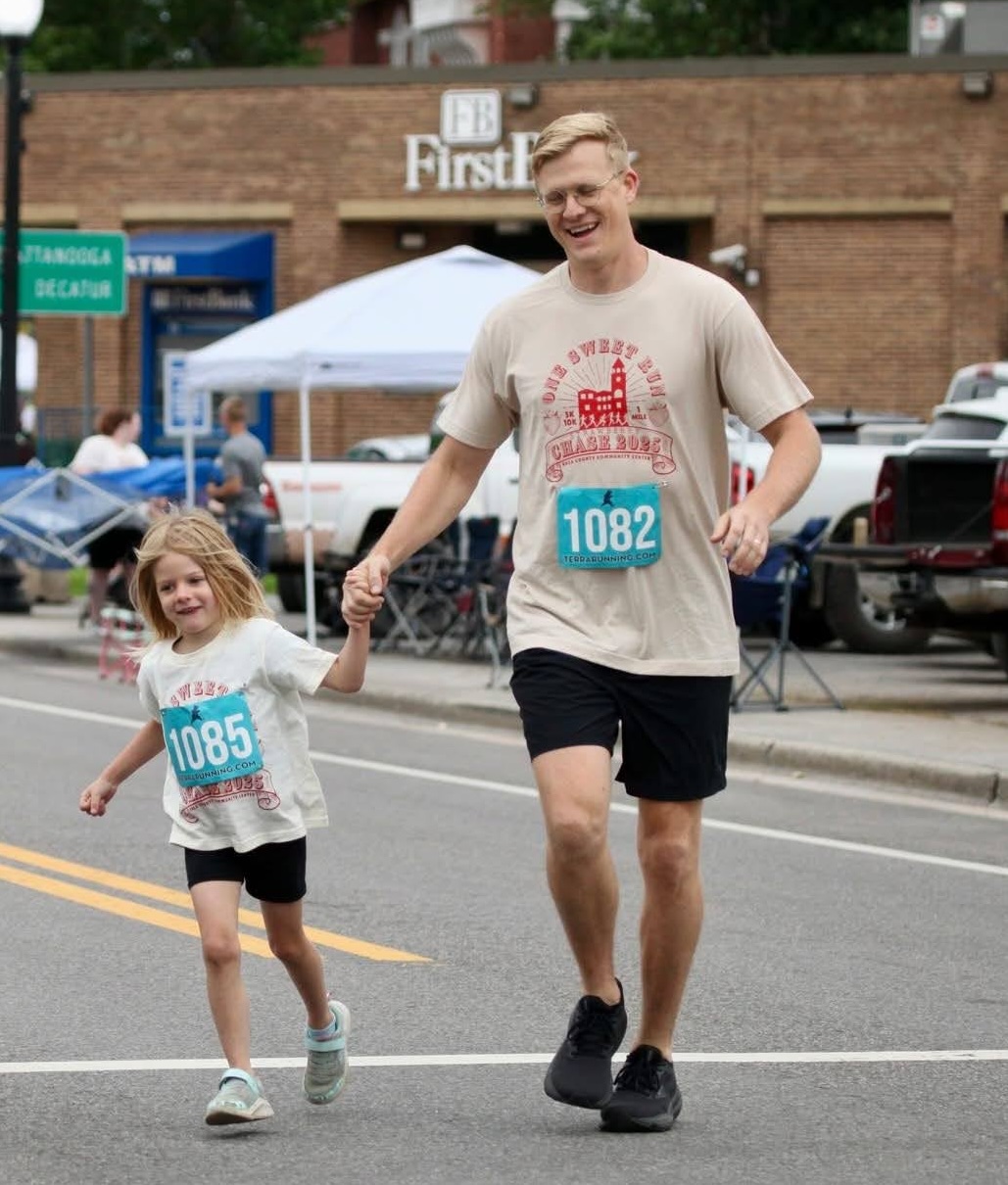 Justus Stout running a community 5K with his daughter in downtown Dayton