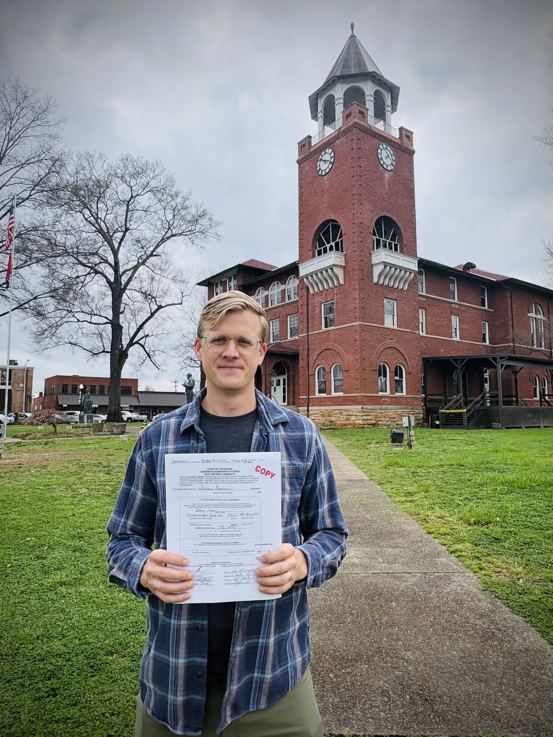 Justus Stout holding his candidate nominating petition in front of the Rhea County Courthouse